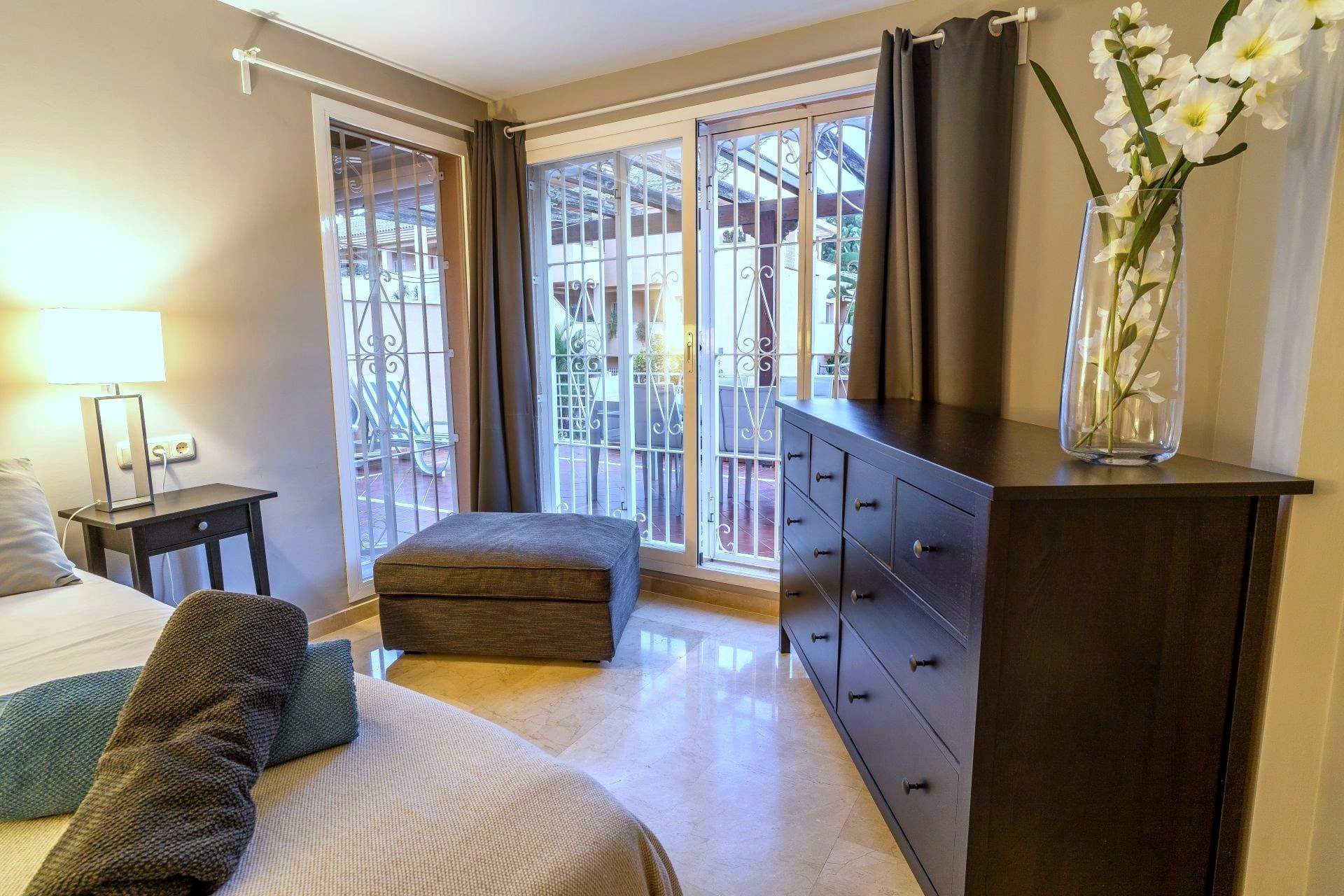 Bedroom with a chest of drawers and doors to the terrace