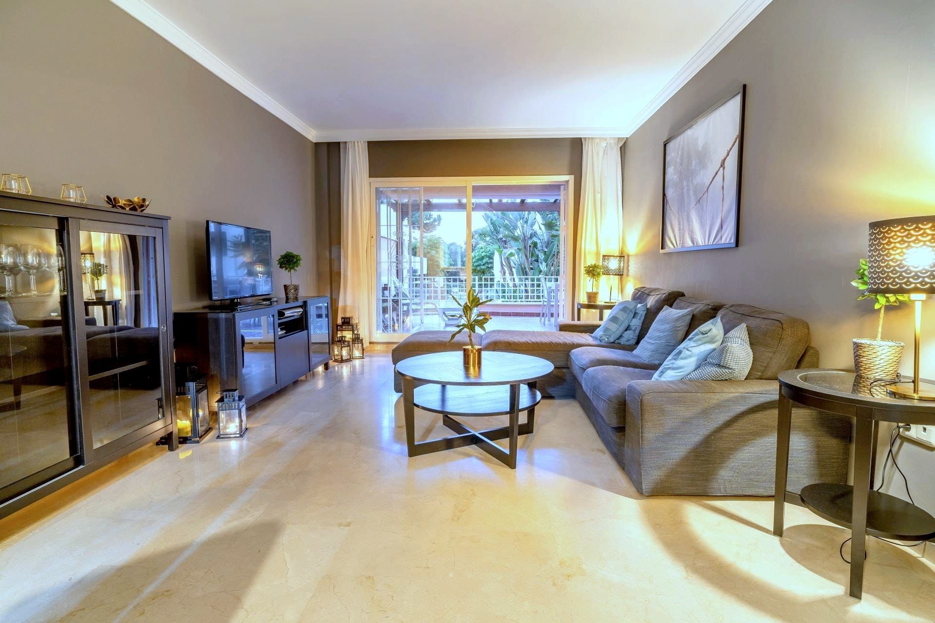 Living room with a corner sofa, smart TV and the door to the terrace