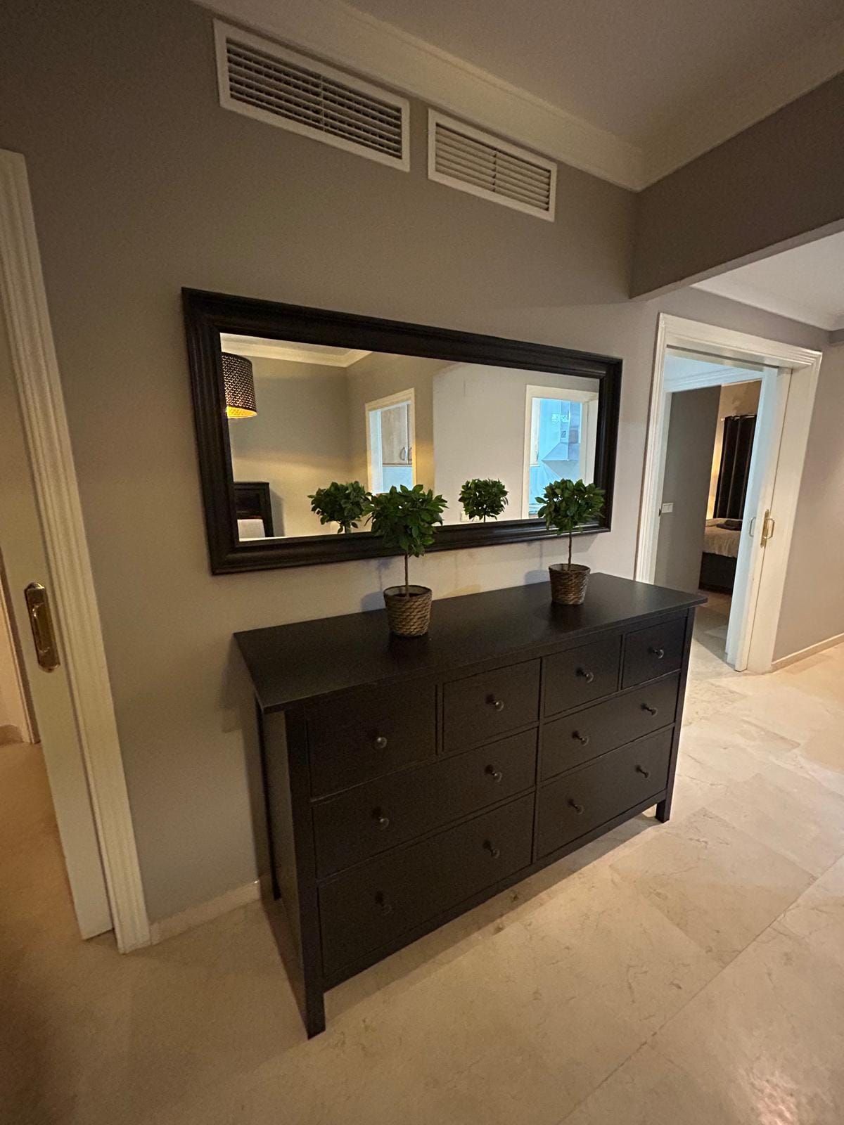 Hallway with a chest of drawers and a mirror